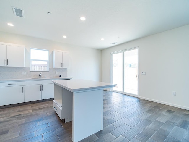 878 Beaver Pond Loop, Madera, CA 93636 - kitchen with a sink, light countertops, decorative backsplash, a kitchen island, and wood finished floors