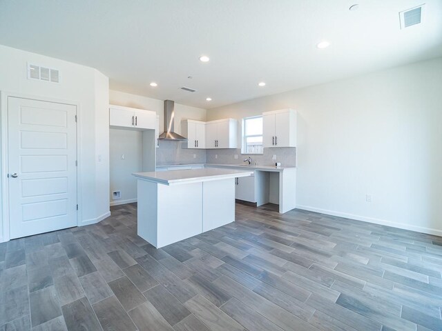 878 Beaver Pond Loop, Madera, CA 93636 - kitchen with wall chimney range hood, a center island, light wood-style floors, white cabinetry, and recessed lighting