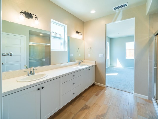 917 Beaver Pond Loop, Madera, CA 93636 - bathroom with a stall shower, wood finished floors, plenty of natural light, and double vanity