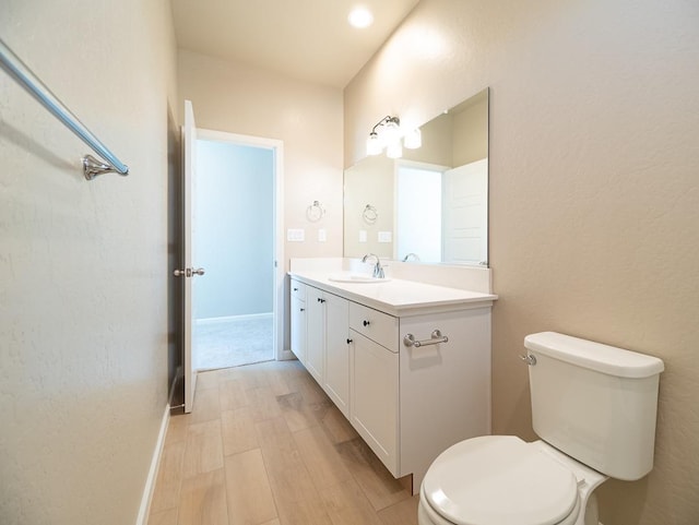 917 Beaver Pond Loop, Madera, CA 93636 - bathroom featuring wood finished floors, vanity, toilet, and baseboards