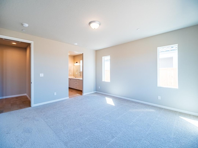 917 Beaver Pond Loop, Madera, CA 93636 - unfurnished bedroom with light carpet, baseboards, and ensuite bath
