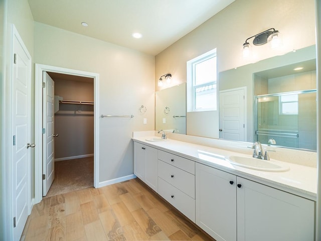 917 Beaver Pond Loop, Madera, CA 93636 - full bathroom with a shower stall, wood finished floors, double vanity, a spacious closet, and recessed lighting