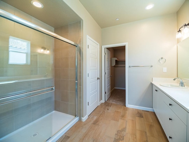 917 Beaver Pond Loop, Madera, CA 93636 - bathroom with a stall shower, wood finished floors, vanity, a spacious closet, and recessed lighting