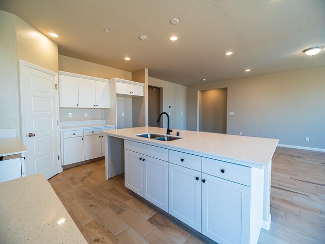 917 Beaver Pond Loop, Madera, CA 93636 - kitchen with a sink, light wood finished floors, white cabinetry, a kitchen island with sink, and recessed lighting