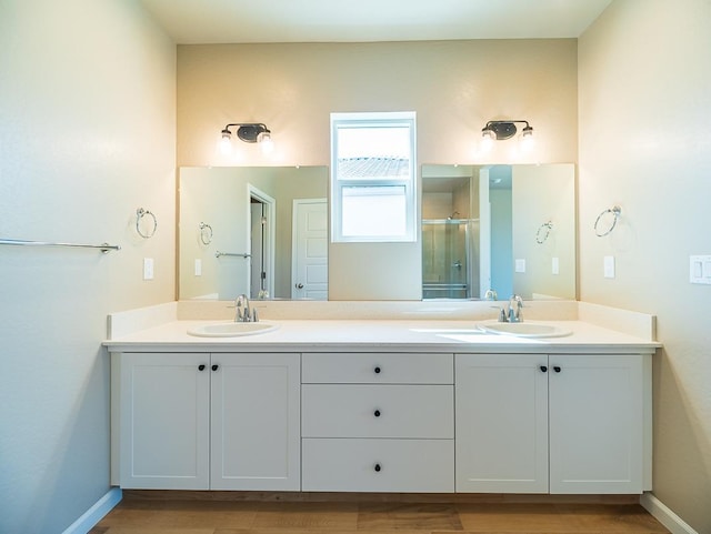 917 Beaver Pond Loop, Madera, CA 93636 - full bathroom featuring a shower stall, double vanity, wood finished floors, and baseboards