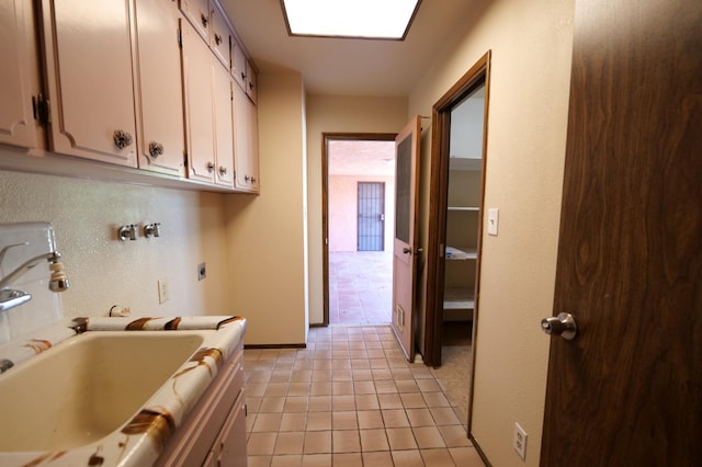 laundry room with cabinet space, hookup for an electric dryer, light tile patterned flooring, and baseboards