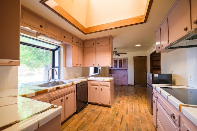 kitchen featuring a sink, black appliances, light countertops, a peninsula, and recessed lighting