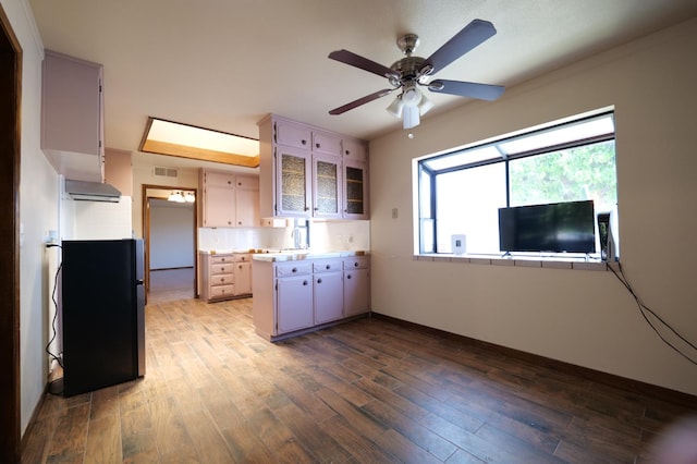 kitchen with wood finished floors, light countertops, and a peninsula