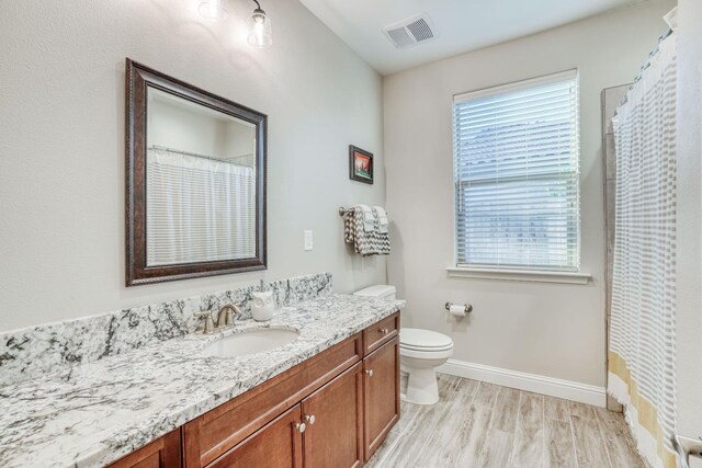 716 Mesa Dr S, Madera, CA 93636 - bathroom with wood finished floors, baseboards, vanity, toilet, and a shower with curtain