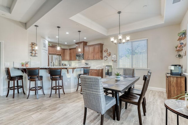 716 Mesa Dr S, Madera, CA 93636 - dining space with a raised ceiling, a chandelier, light wood-style flooring, ornamental molding, and baseboards