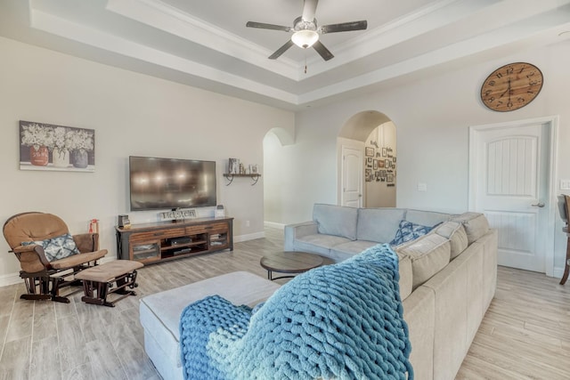 716 Mesa Dr S, Madera, CA 93636 - living area featuring arched walkways, a raised ceiling, a ceiling fan, light wood-type flooring, and baseboards