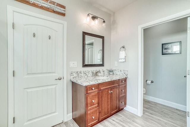 716 Mesa Dr S, Madera, CA 93636 - bathroom featuring wood finished floors, baseboards, toilet, and vanity
