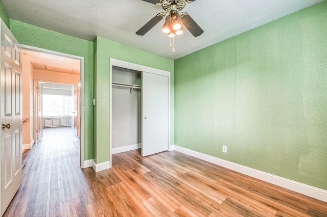 580 W Alluvial Ave, Clovis, CA 93611 - unfurnished bedroom with light wood finished floors, a textured wall, baseboards, a closet, and ceiling fan
