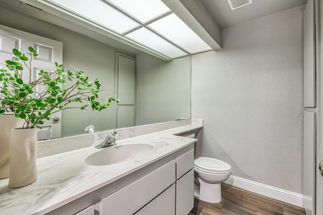 580 W Alluvial Ave, Clovis, CA 93611 - half bathroom featuring wood finished floors, baseboards, vanity, toilet, and a textured wall
