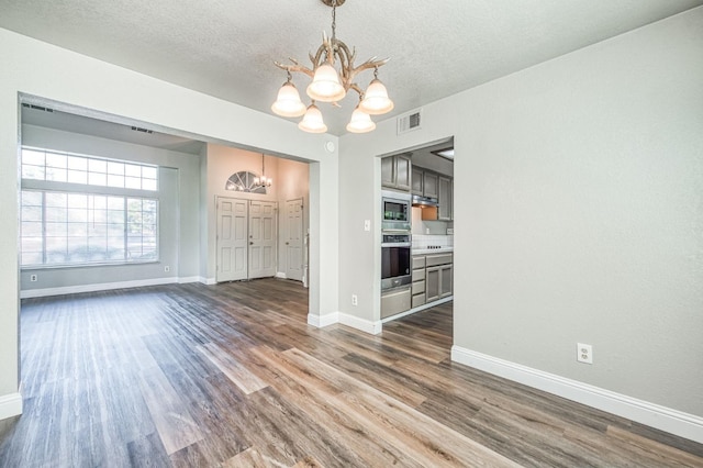 580 W Alluvial Ave, Clovis, CA 93611 - unfurnished dining area with a chandelier, dark wood-style floors, a textured ceiling, and baseboards