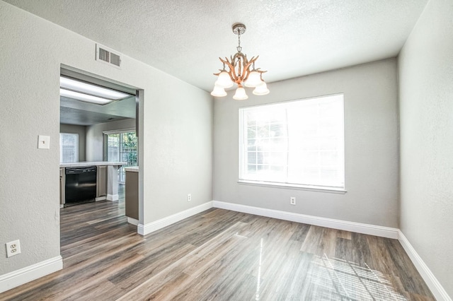 580 W Alluvial Ave, Clovis, CA 93611 - unfurnished dining area featuring a chandelier, wood finished floors, a textured ceiling, a textured wall, and baseboards