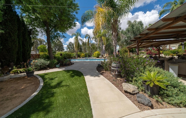 surrounding community with a pool and a yard