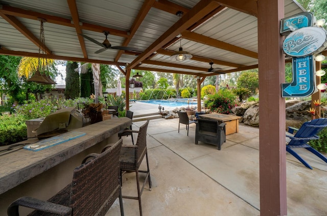 view of patio featuring ceiling fan and an outdoor pool