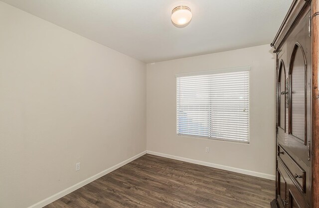 1073 E Pennsylvania Ave, Fresno, CA 93720 - unfurnished room with baseboards and dark wood-style floors