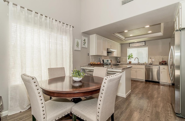 1073 E Pennsylvania Ave, Fresno, CA 93720 - dining room with dark wood-style flooring, a raised ceiling, crown molding, and recessed lighting
