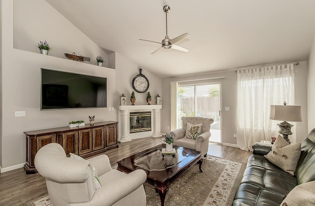 1073 E Pennsylvania Ave, Fresno, CA 93720 - living area featuring a ceiling fan, wood finished floors, vaulted ceiling, a glass covered fireplace, and baseboards