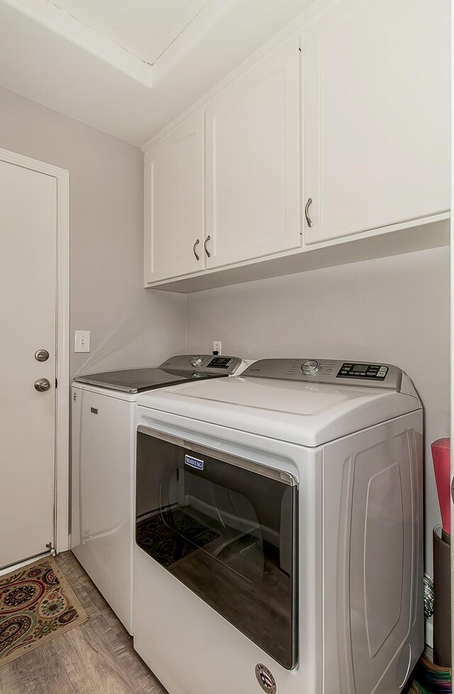 1073 E Pennsylvania Ave, Fresno, CA 93720 - laundry area featuring washing machine and dryer, cabinet space, and light wood-style flooring