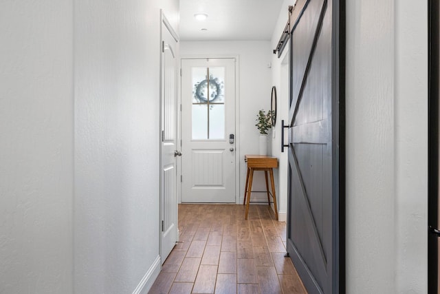 6772 E Ramona Way, Fresno, CA 93727 - doorway to outside with baseboards, a barn door, and dark wood-style flooring