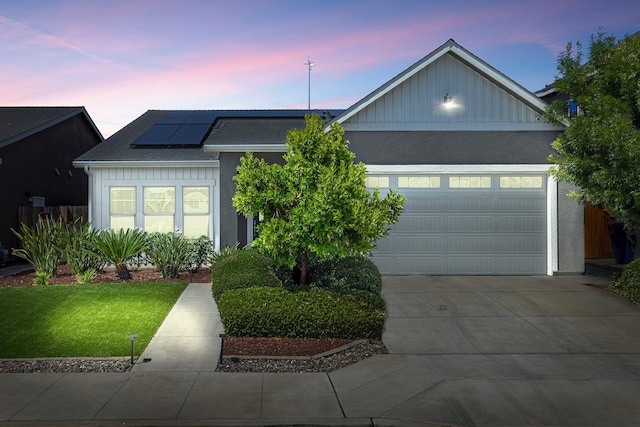 6772 E Ramona Way, Fresno, CA 93727 - single story home featuring board and batten siding, roof mounted solar panels, concrete driveway, an attached garage, and a lawn