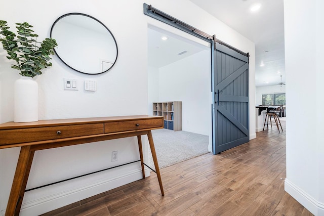 6772 E Ramona Way, Fresno, CA 93727 - hall featuring a barn door, wood finished floors, recessed lighting, and baseboards
