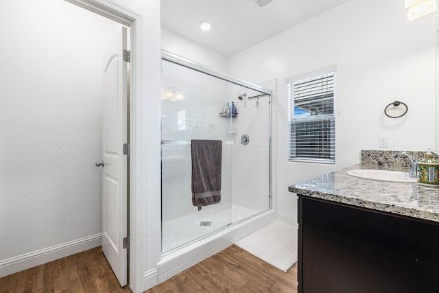 6772 E Ramona Way, Fresno, CA 93727 - bathroom featuring wood finished floors, a shower stall, vanity, and baseboards