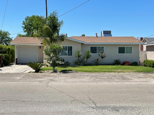 ranch-style home featuring stucco siding, an attached garage, driveway, and a front lawn