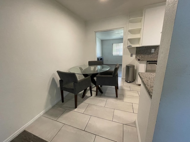 dining space with baseboards and light tile patterned flooring