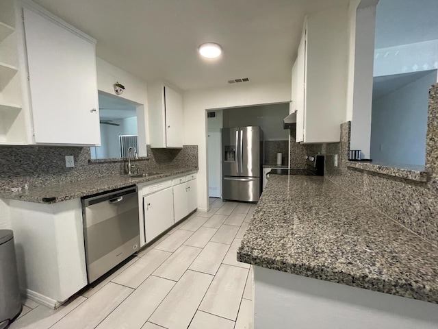 kitchen with stainless steel appliances, a sink, white cabinetry, open shelves, and decorative backsplash