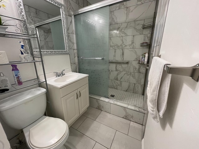bathroom with toilet, a shower stall, vanity, and tile patterned flooring