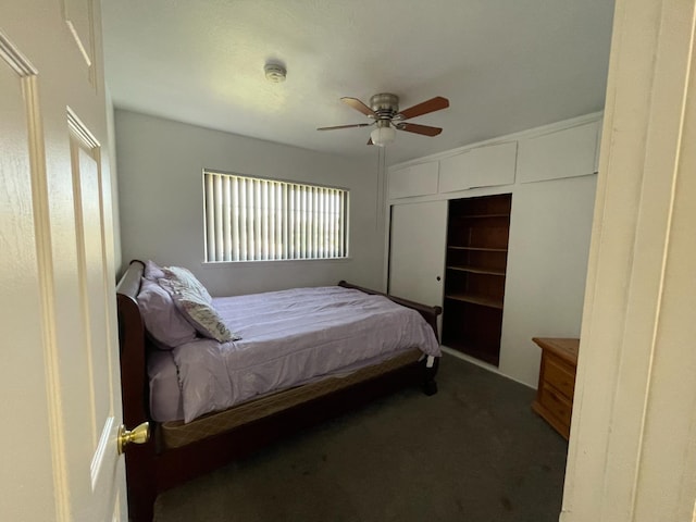 carpeted bedroom featuring ceiling fan and a closet