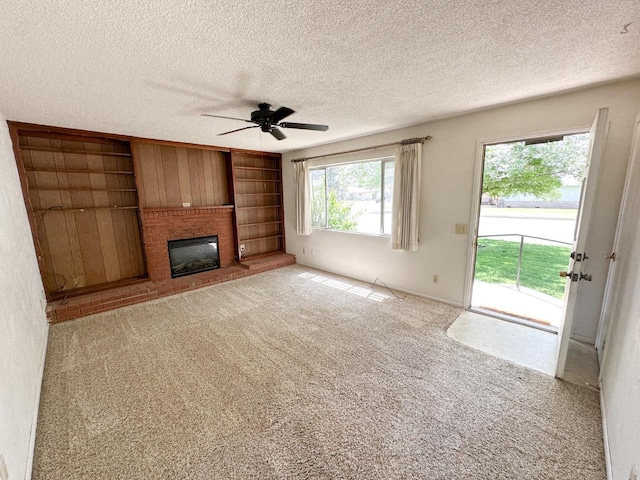 1482 W Thurman, Porterville, CA 93257 - unfurnished living room with a ceiling fan, a fireplace, a textured ceiling, carpet floors, and built in shelves