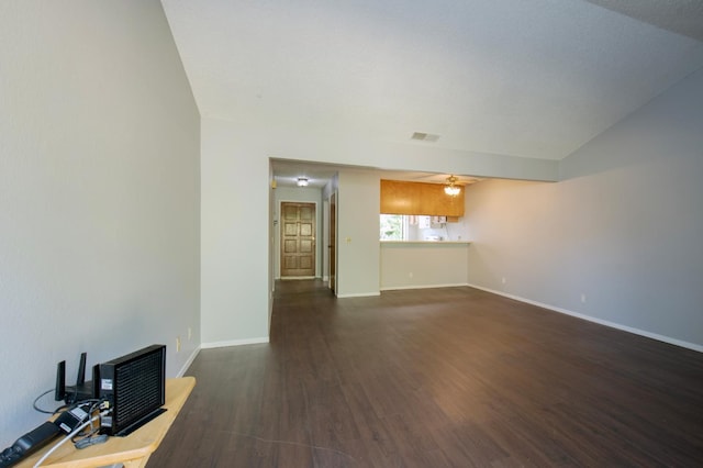 unfurnished living room featuring dark wood-type flooring, ceiling fan, baseboards, and lofted ceiling