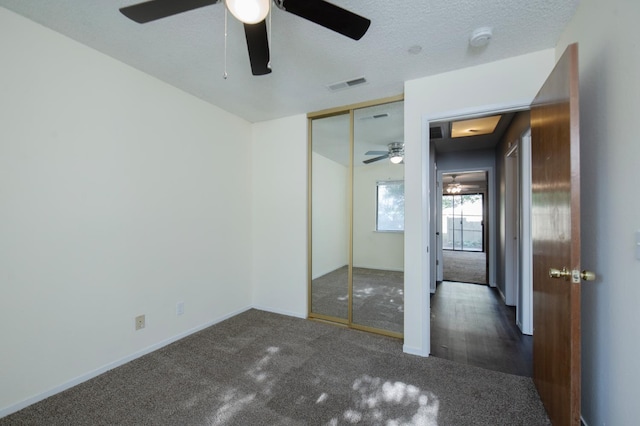 unfurnished bedroom featuring carpet, baseboards, a closet, and a ceiling fan
