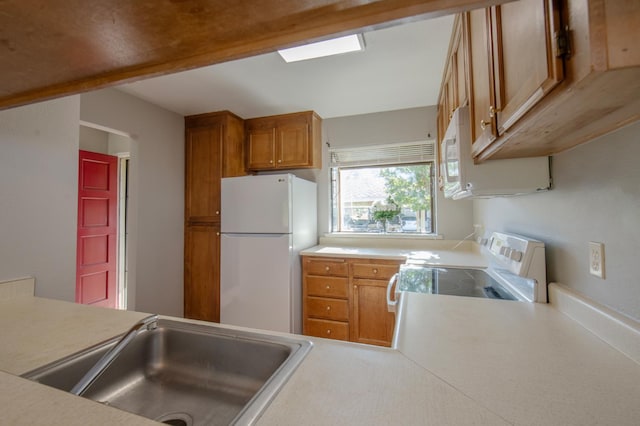 kitchen with white appliances, a sink, brown cabinetry, and light countertops