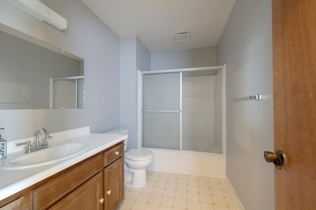bathroom featuring toilet, vanity, and combined bath / shower with glass door