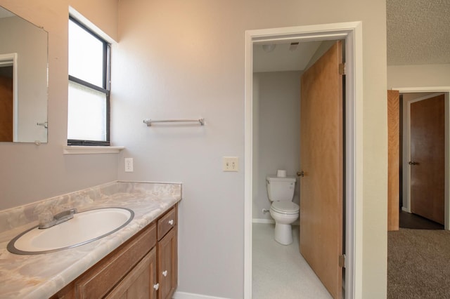bathroom with vanity, toilet, and baseboards