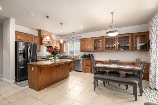 1710 N Filbert Ave, Clovis, CA 93619 - kitchen featuring stainless steel appliances, a center island, glass insert cabinets, a breakfast bar area, and decorative light fixtures