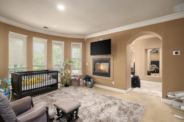 1710 N Filbert Ave, Clovis, CA 93619 - carpeted bedroom with crown molding, arched walkways, a glass covered fireplace, and baseboards