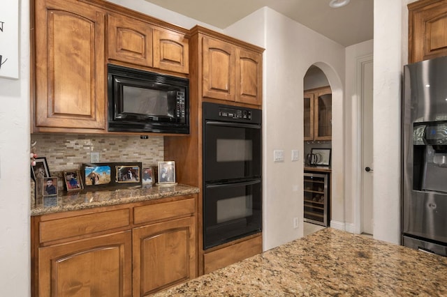 1710 N Filbert Ave, Clovis, CA 93619 - kitchen with black appliances, wine cooler, dark stone counters, brown cabinets, and backsplash