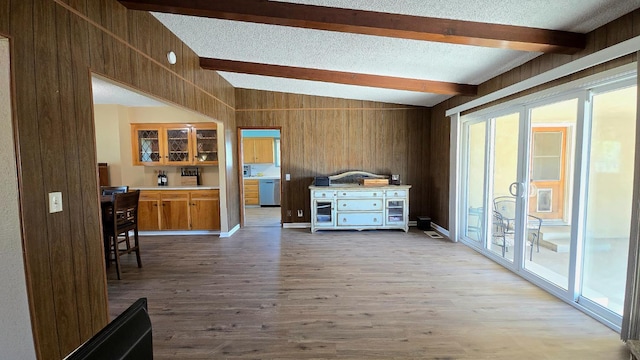 1205 Pine St, Selma, CA 93662 - living room with wood walls, beamed ceiling, wood finished floors, and a textured ceiling