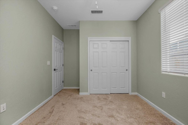 unfurnished bedroom with carpet, a closet, and baseboards
