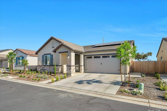 single story home with a garage, roof mounted solar panels, fence, concrete driveway, and stucco siding