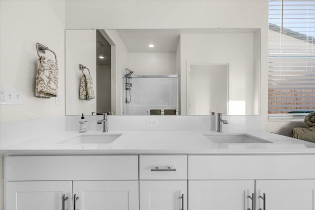 bathroom featuring a shower stall and double vanity