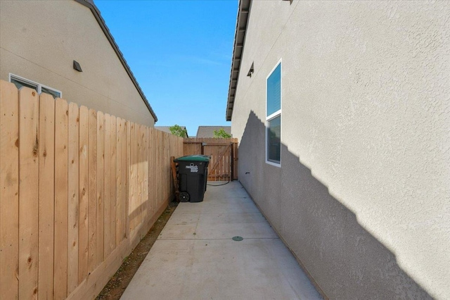 view of side of property featuring stucco siding and fence
