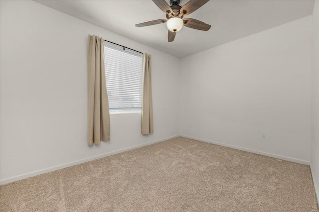 spare room with light carpet, baseboards, and a ceiling fan
